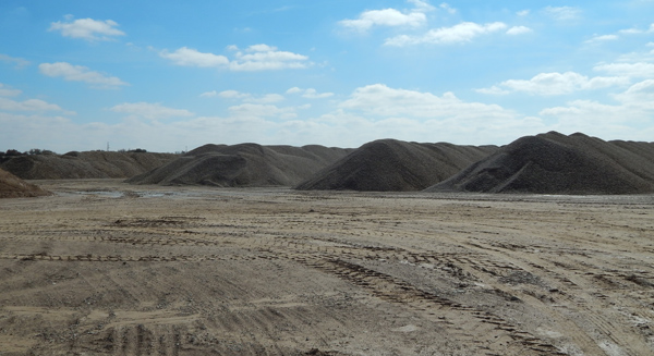 A dirt field with some hills in the background